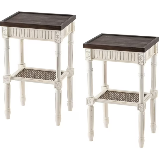 A pair of distressed white farmhouse-style end tables with dark espresso tray tops and woven wicker lower shelves.