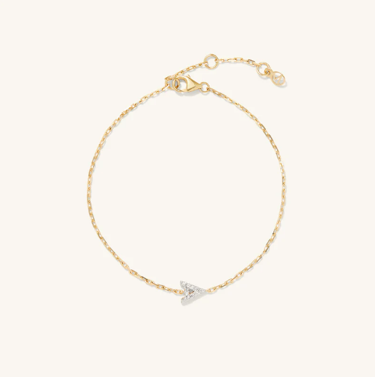 A gold chain bracelet with a small, shimmering diamond-encrusted letter 'A' charm in the center.