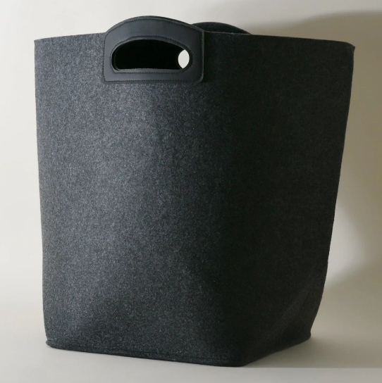 Dark grey felt storage bin with black handles, a minimalist and modern laundry hamper or organizing basket.